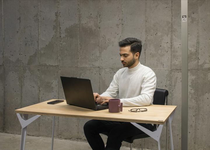 a man sitting at a table using a laptop computer