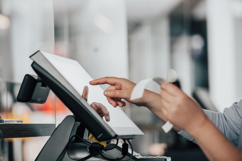 a person is using a pos machine in a store to manage an order