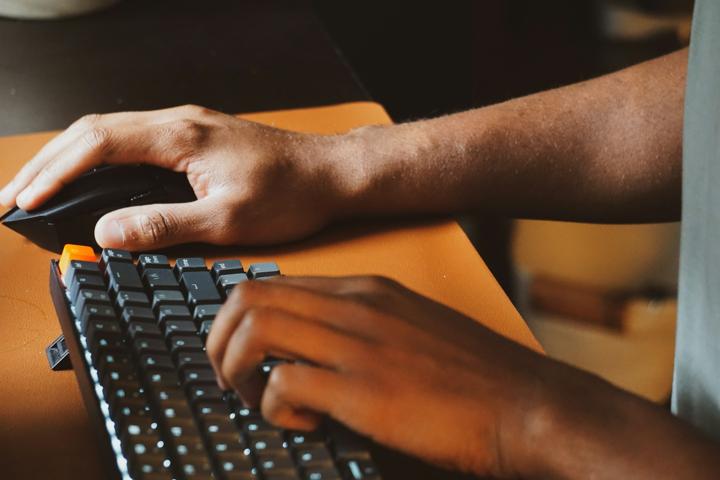 a person using a computer keyboard and mouse