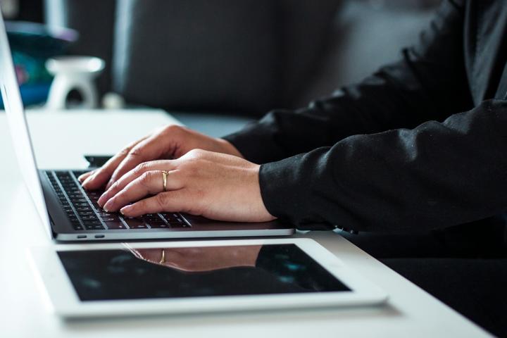 man in black dress shirt using laptop