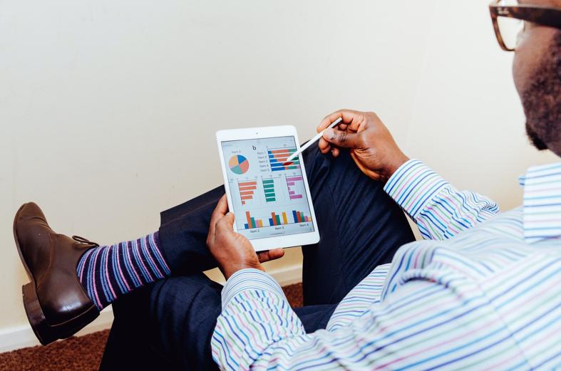 NetSuite SuiteAnalytics person sitting on chair holding iPad