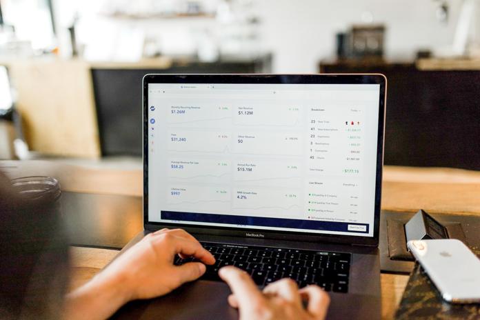 person at computer using multi-book accounting program