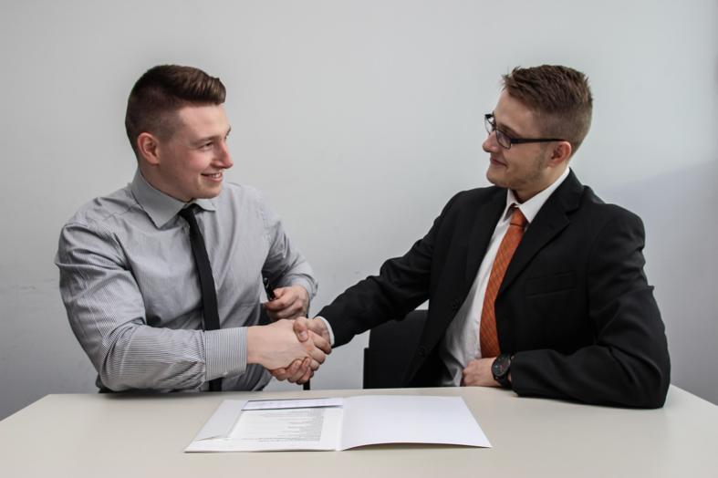 NetSuite CRM two men facing each other while shake hands and smiling