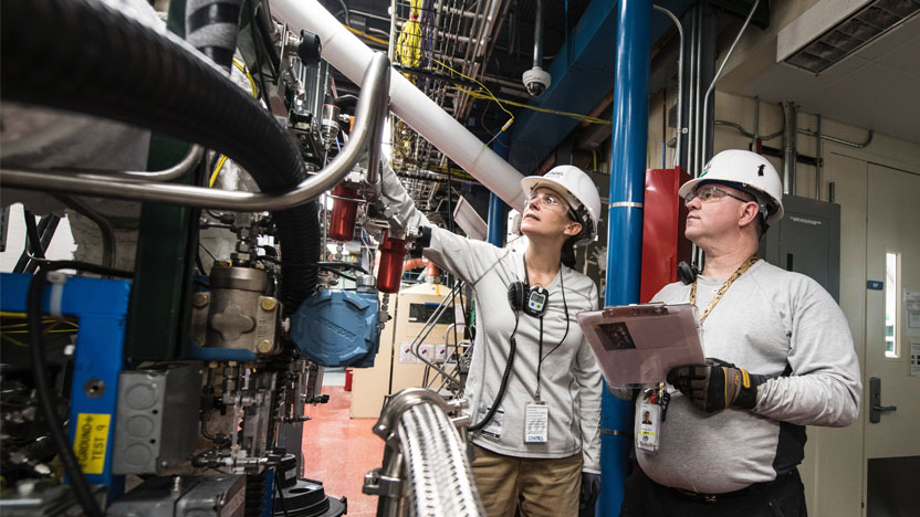 industrial workers inspect a plastic extrusion machine