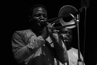 man in dress shirt playing trumpet