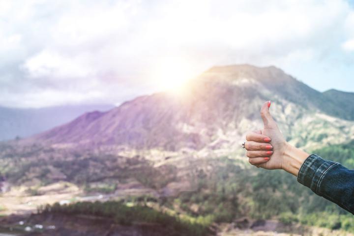 human showing hand on top of mountain