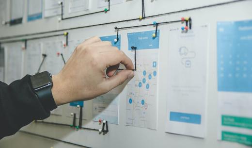 person working on blue and white paper on board