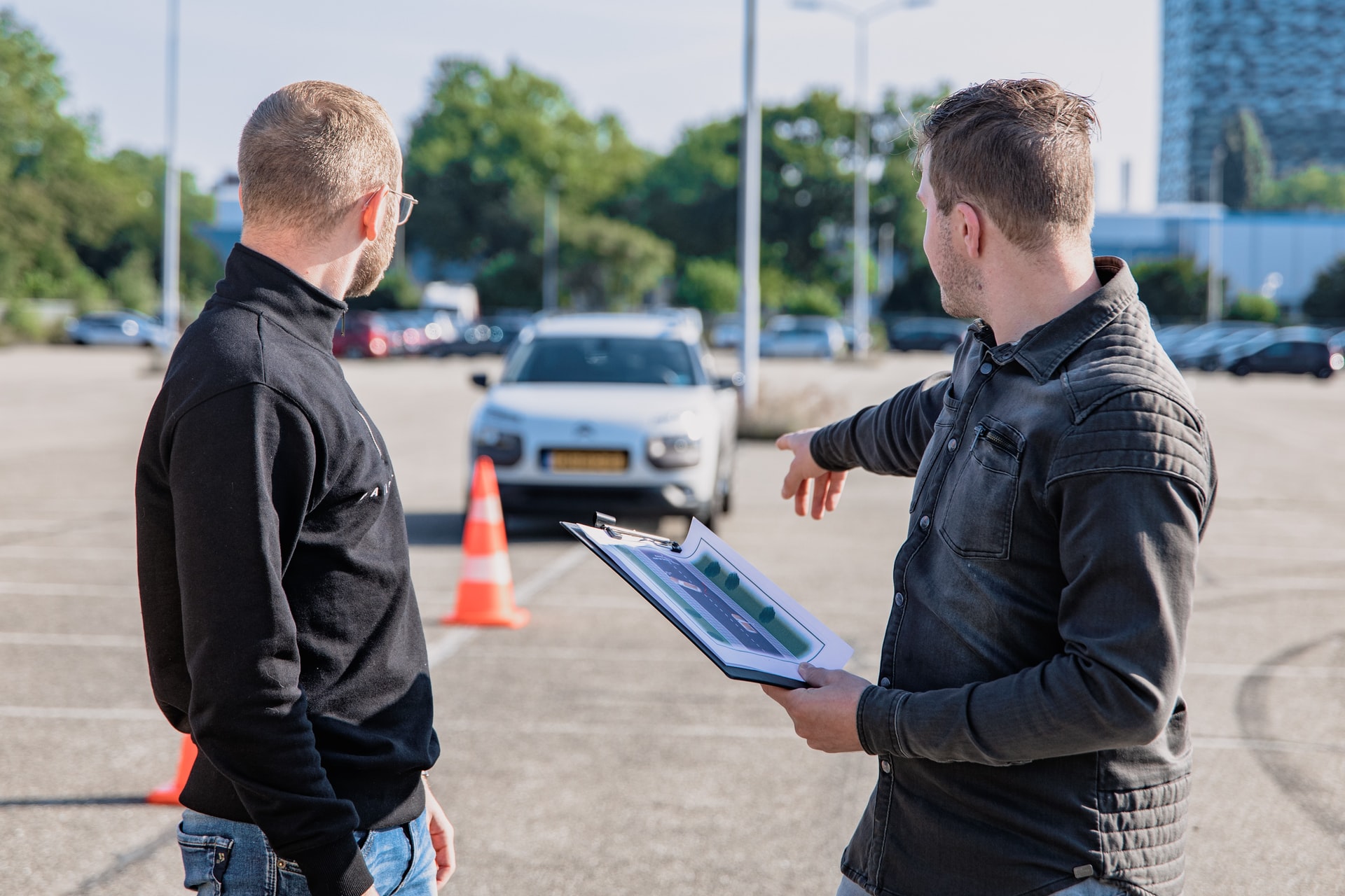 two people standing in front of a car