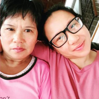 Caregiver hugging and smiling with her mother