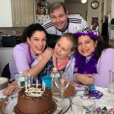 two sister caregivers with their mother having a party and smiling