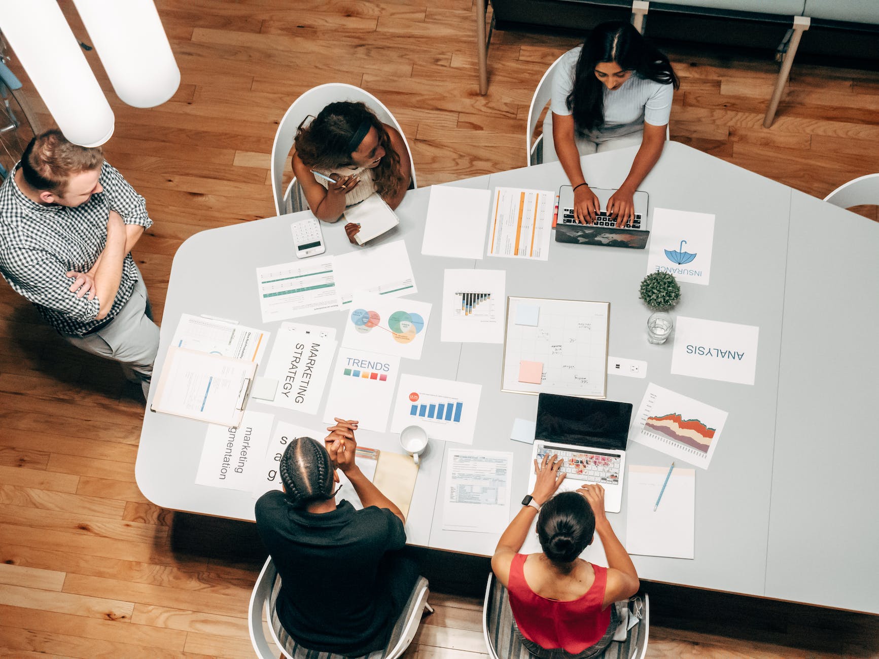 A conference table of diverse people discuss copy and marketing resources for businesses, as represented on the page.