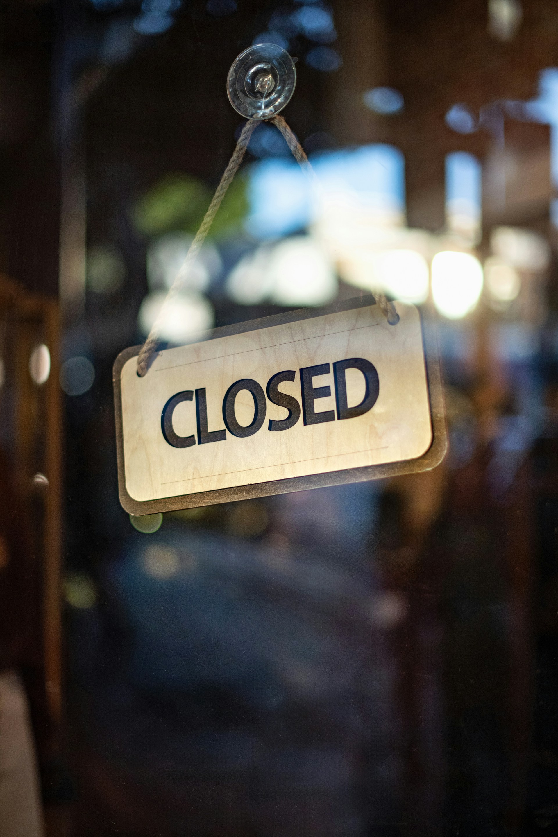A closed sign hanging from a glass door