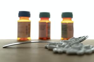 medication capsules on wooden surface and spoon