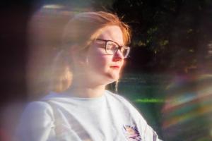 woman wearing white crew-neck top standing on green grass field